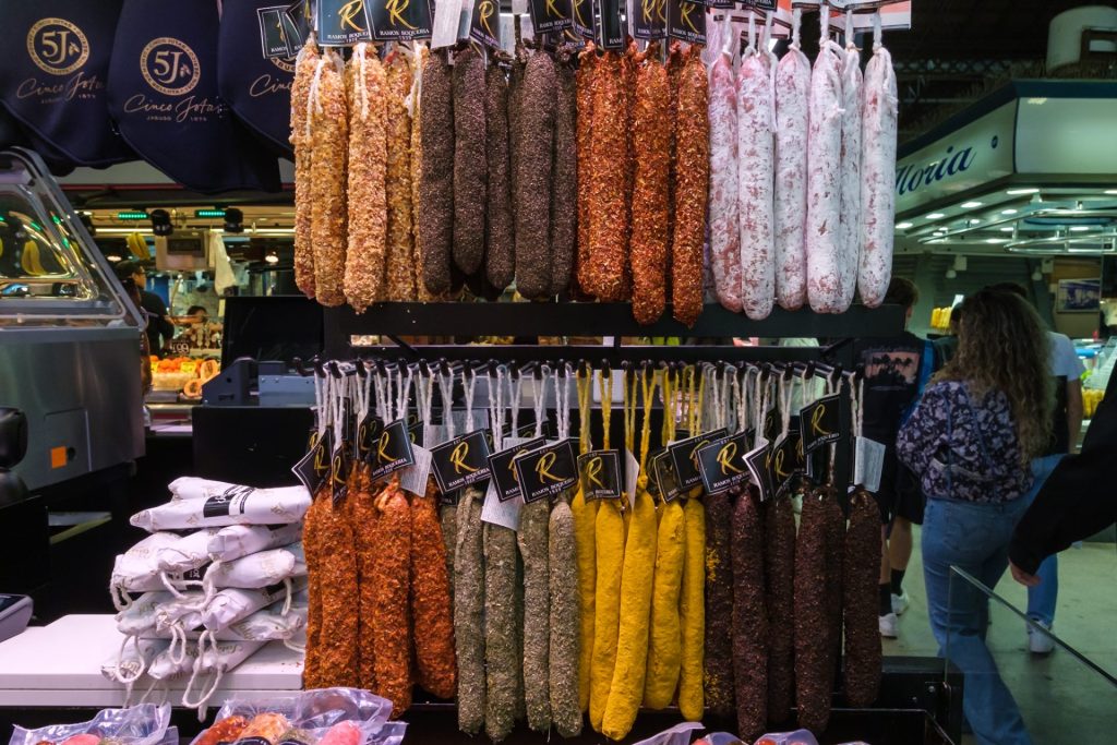 Catalan-dry cured sausages of different varieties hanging on display at La Boqueria Market.