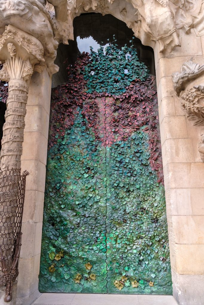 Intricately designed metal door of leaves and flowers of the Nativity facade.