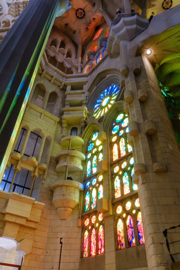 Rainbow of colors streaming through the stained glass windows inside the Sagrada Familia