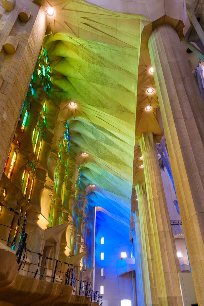 Rainbow of colors streaming through the stained glass windows inside the Sagrada Familia